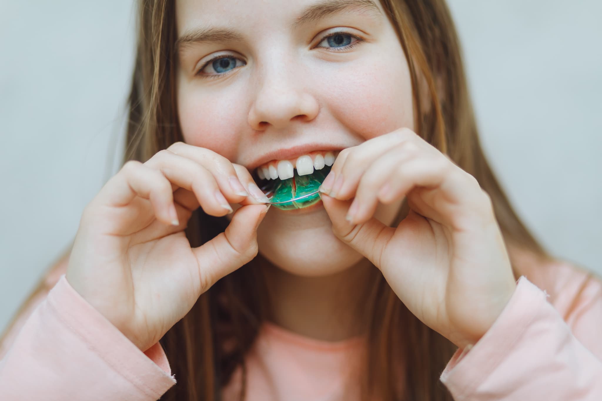 床矯正の装置を笑顔で装着する子ども