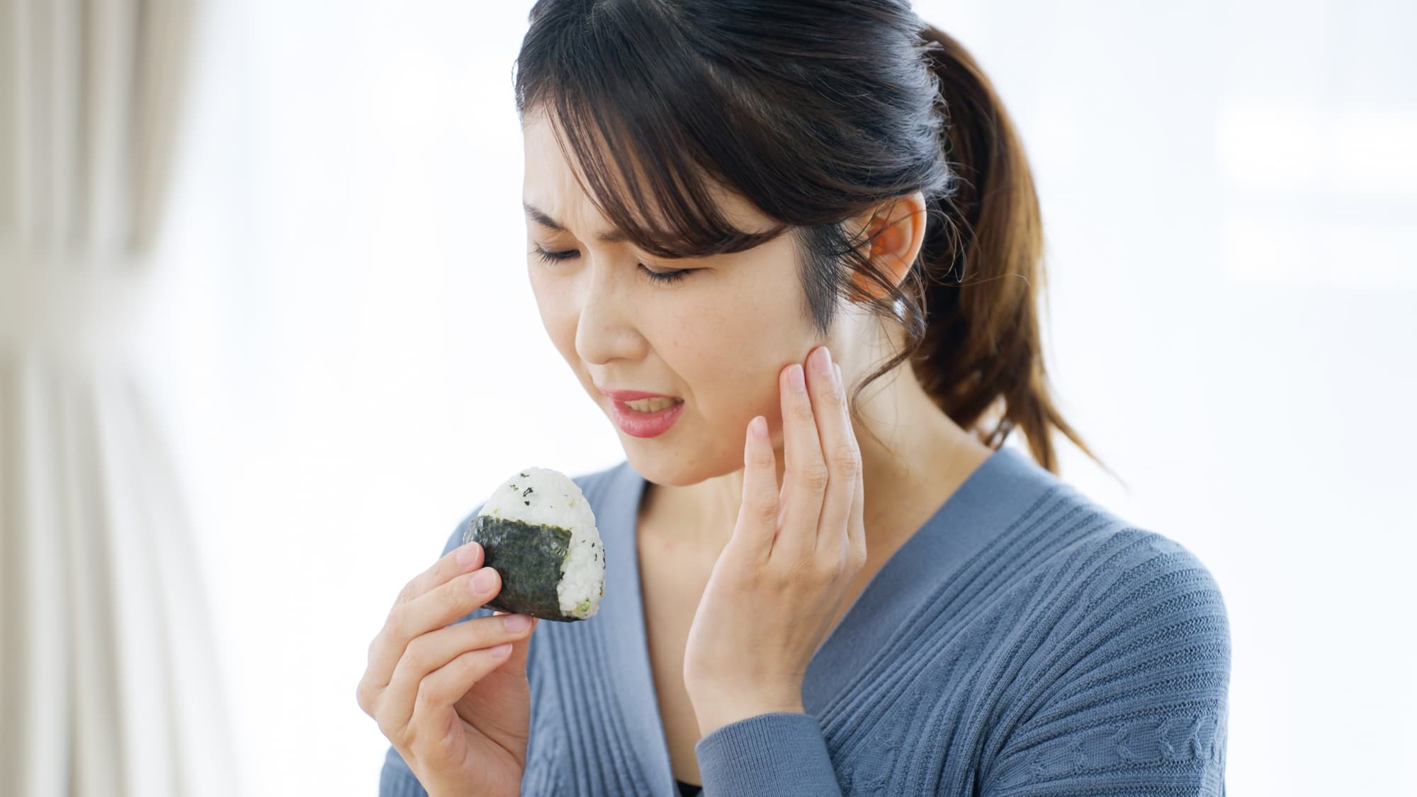 放置した虫歯が痛んで噛むのがつらい女性