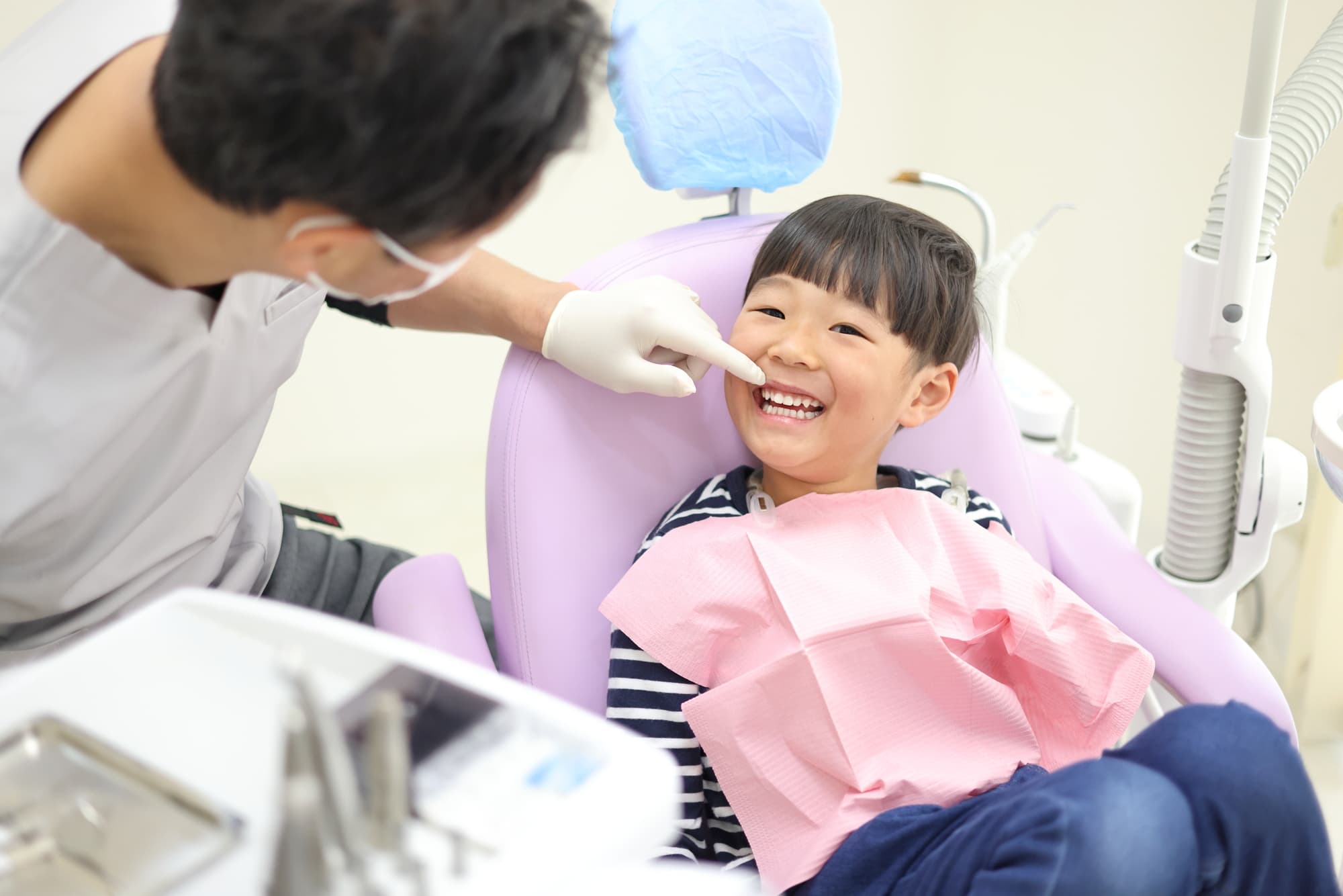 歯科医院で女の子の歯並びの確認をする様子