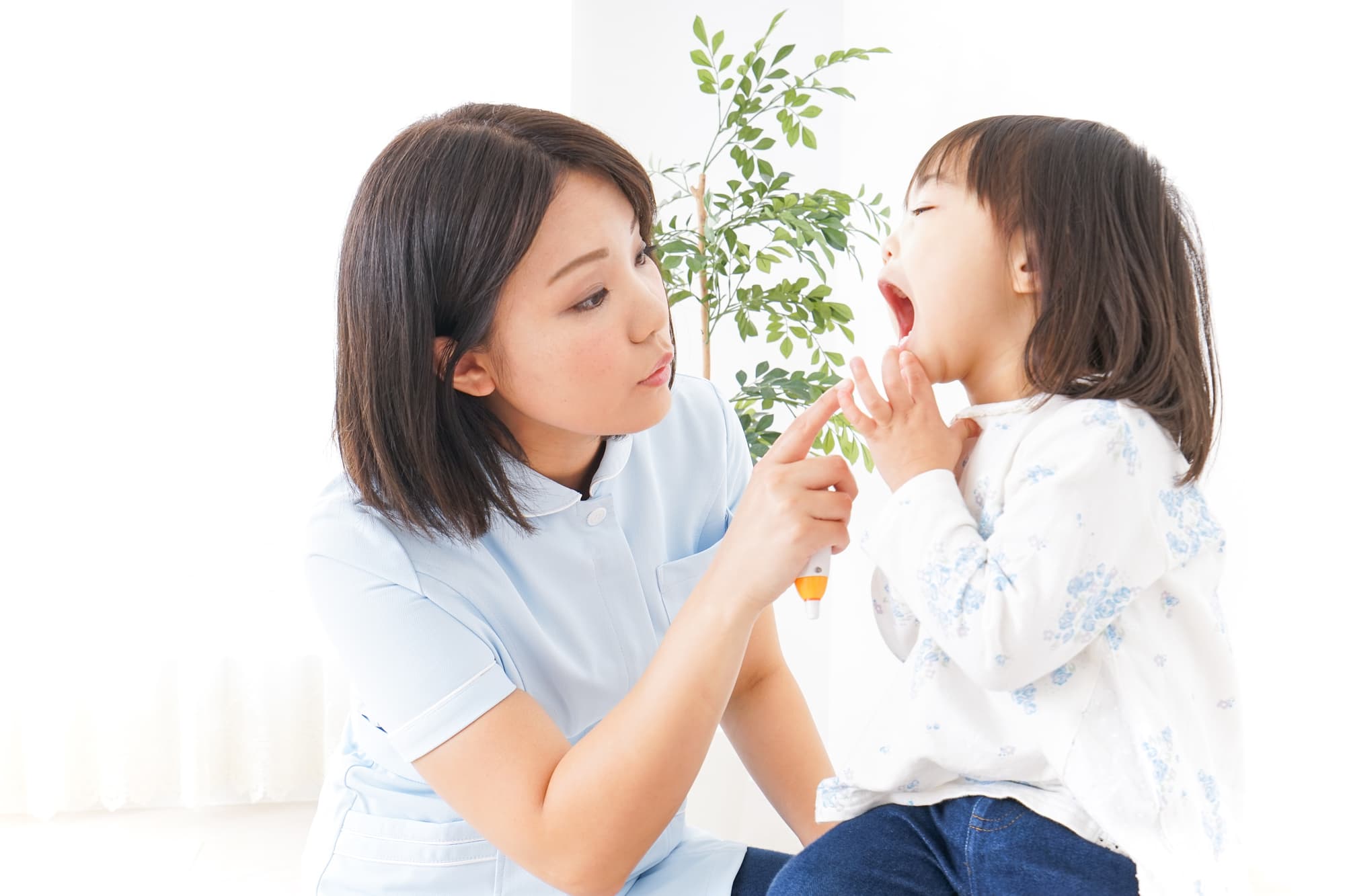 大きな口を開けて歯科検診を受ける子ども