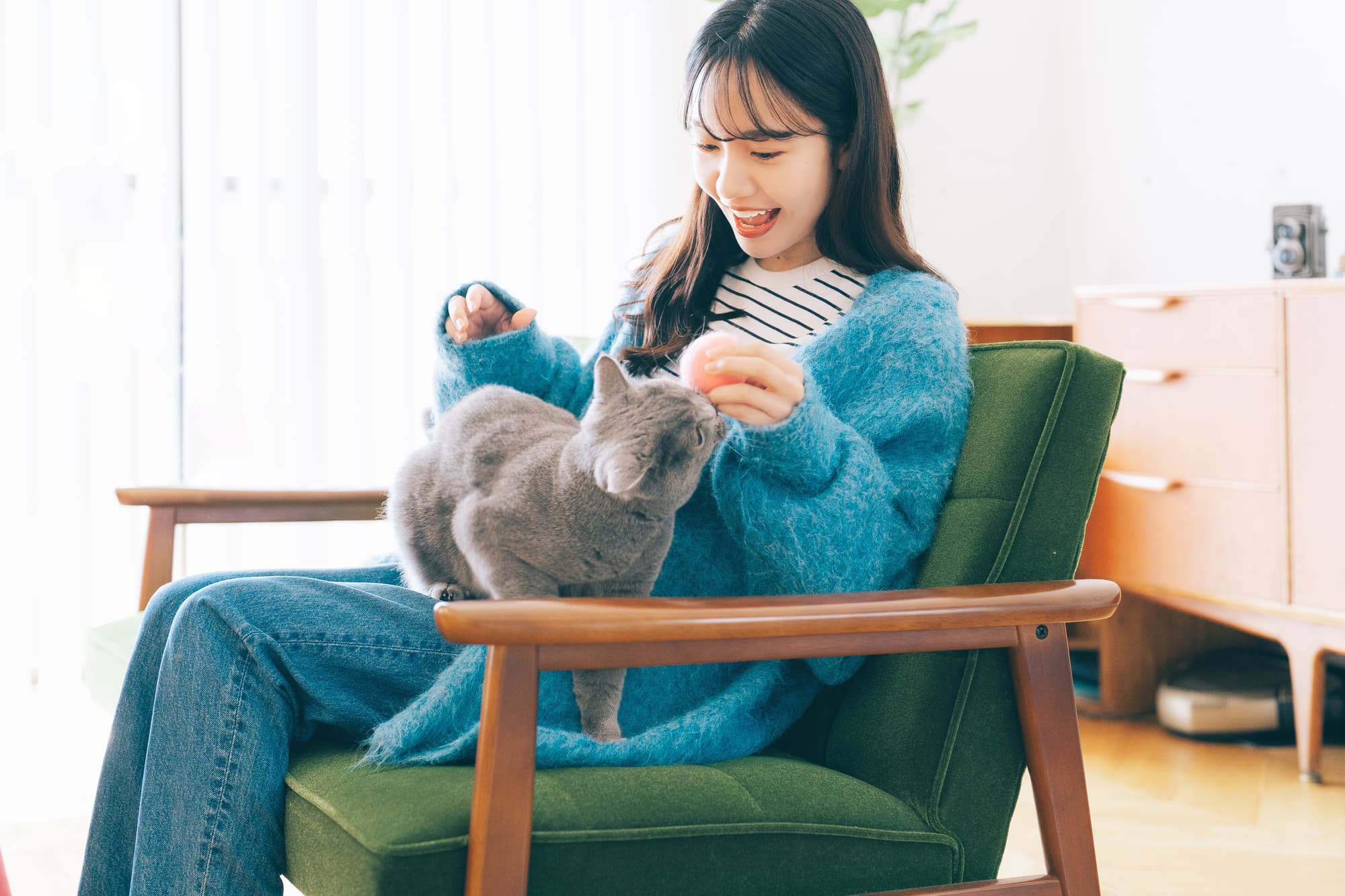 リビングで猫と戯れる笑顔の女性