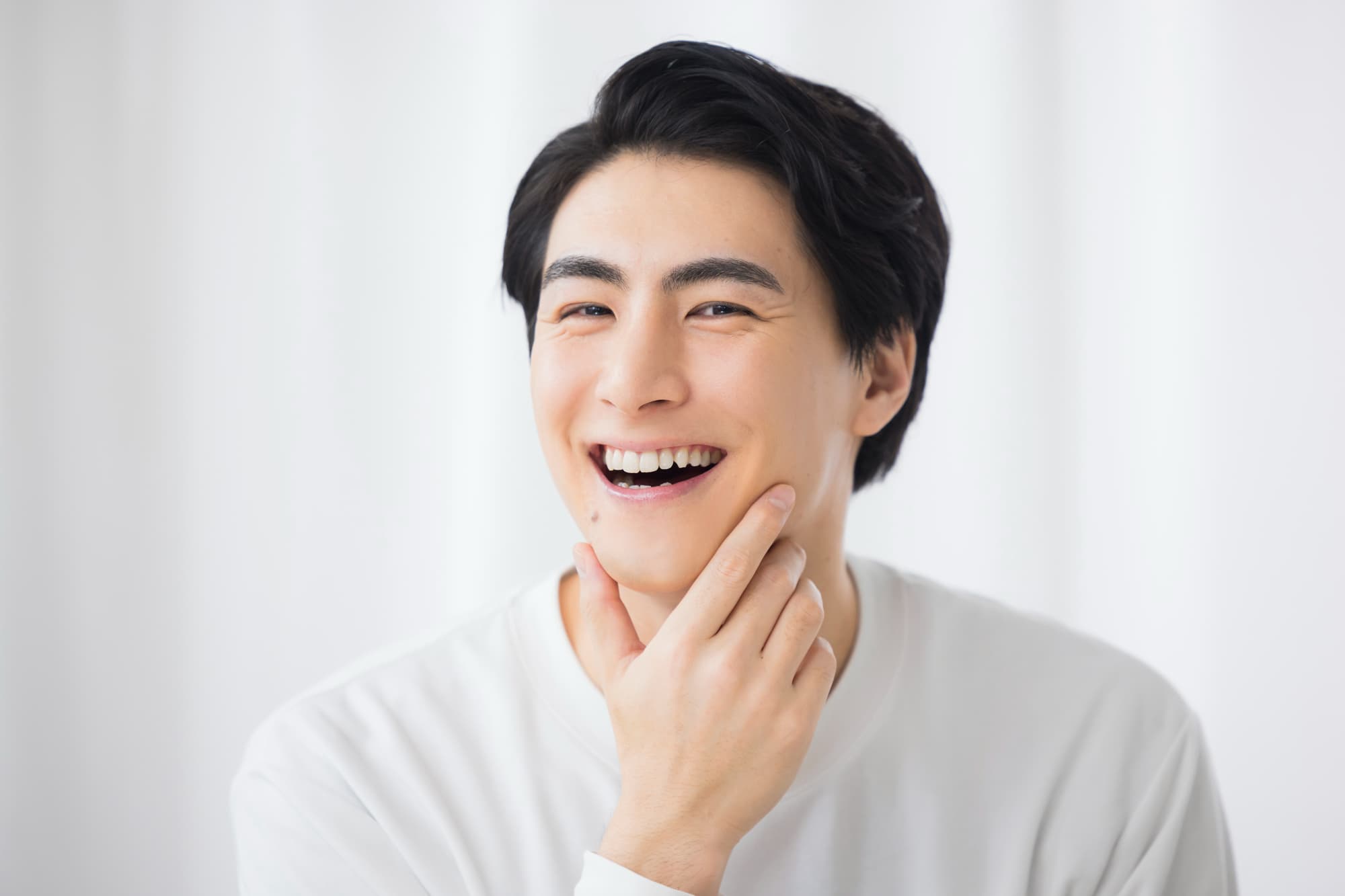 ブリッジ治療をした歯を見せる笑顔の男性