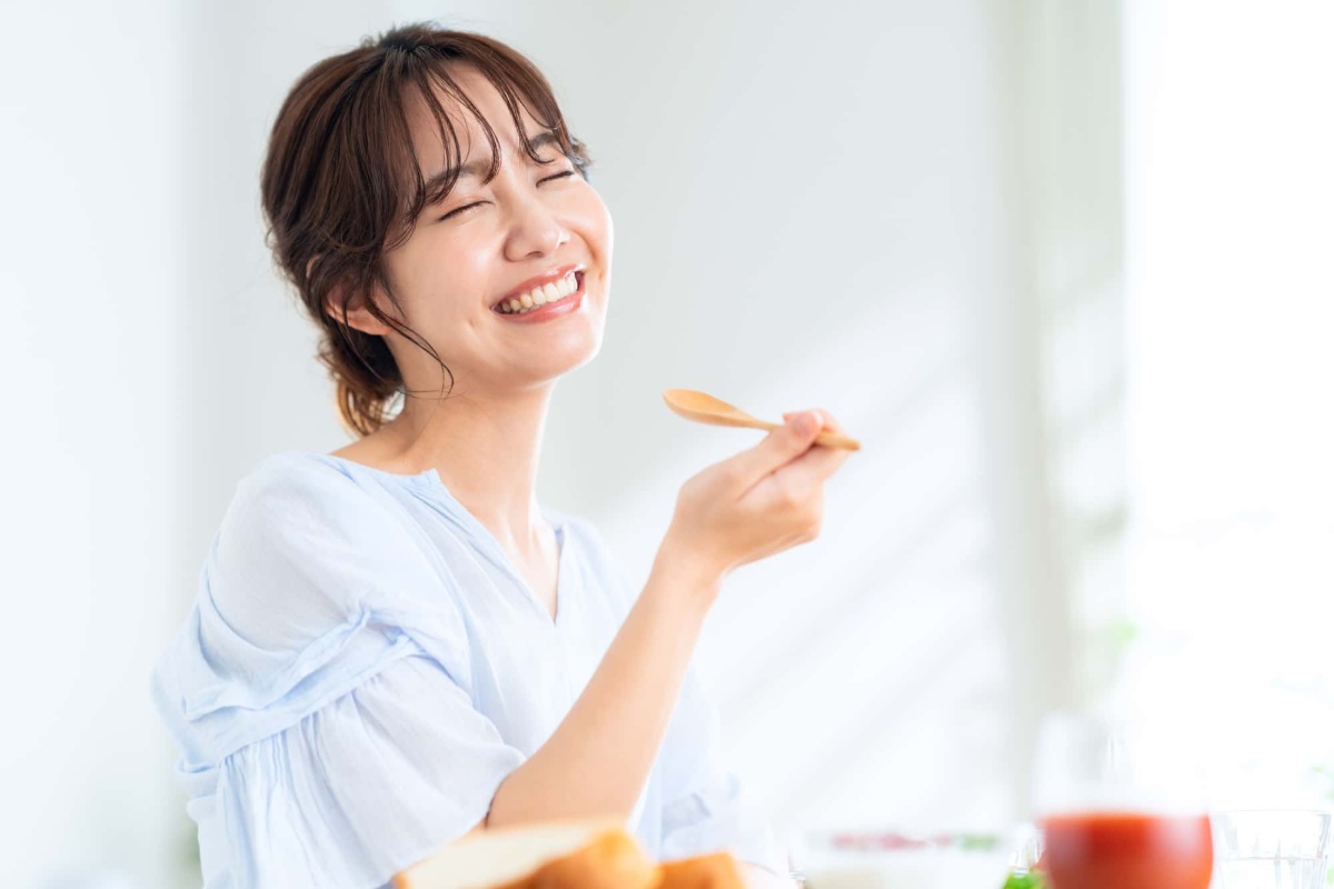 奥歯の虫歯を治して食事を楽しむ女性